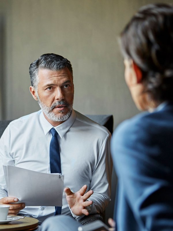 Zwei Männer sitzen sich im Gespräch gegenüber