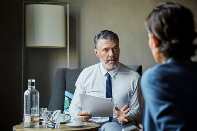Zwei Männer sitzen sich im Gespräch gegenüber