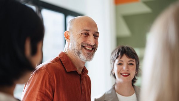 Mann stehend in einer Gesprächsrunde
