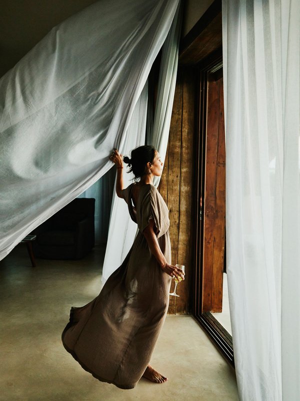Elegante Frau vor offenem Fenster