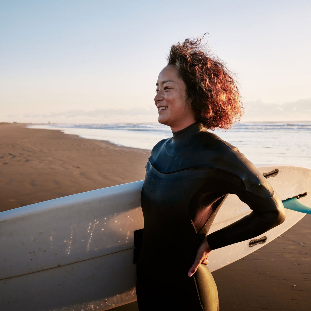 Frau mit Surfbrett am Strand