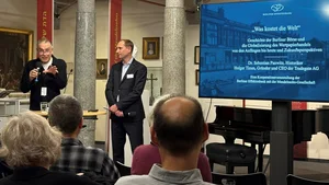 Zwei Sprecher vor Bildschirm